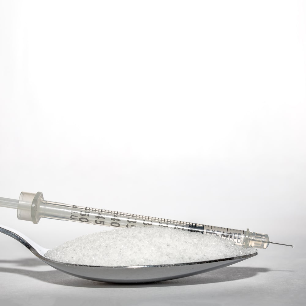 Diabetes Loeffel Zucker und Insulinspritze